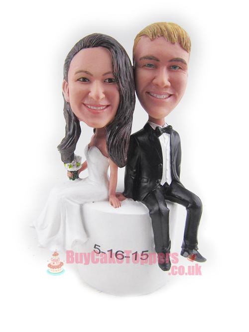 couple sit on cake topper 